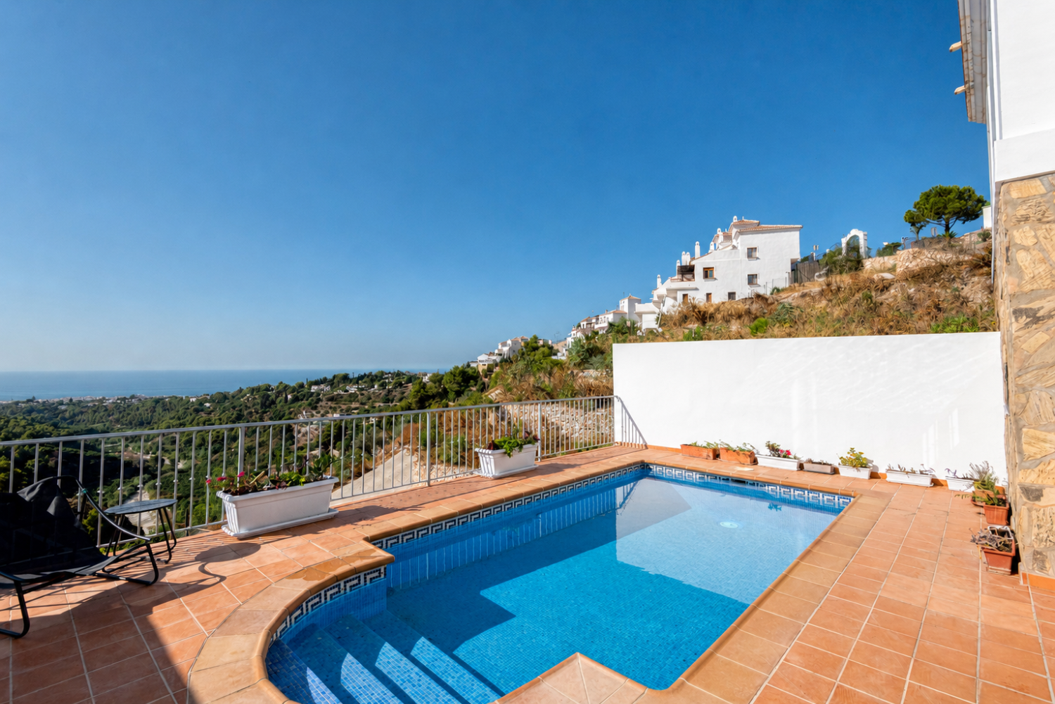 Villa med privat basseng, parkering og utsikt over havet og fjellene.