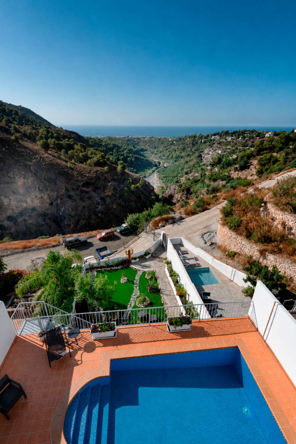 Villa med privat basseng, parkering og utsikt over havet og fjellene.